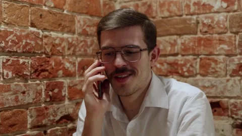 Man on phone against brick wall 库存影片 342779701