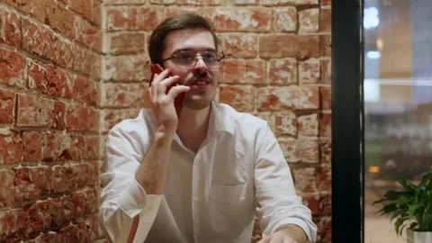 Man on phone in cafe with brick wall Stock Footage 342780081