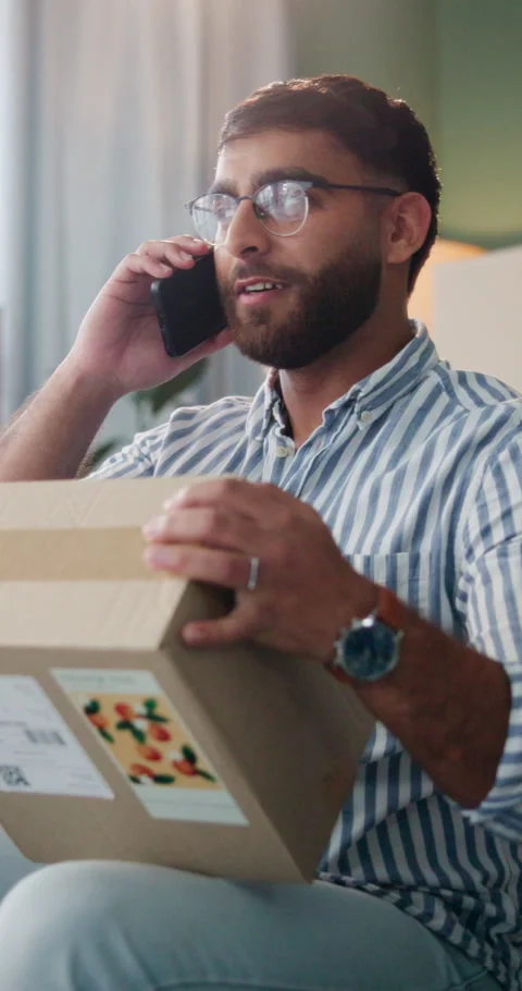 Man, phone call and update in home with box for ecommerce, communication and Stock Footage 337222898