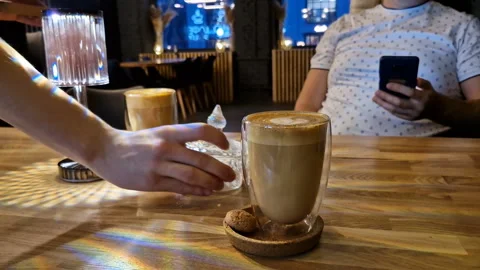A man with a phone, drinking coffee in a cafe, sending text messages. Stock Footage 245907777