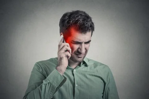 Man on the phone with headache. Cellular mobile radiation concept Stock Photos