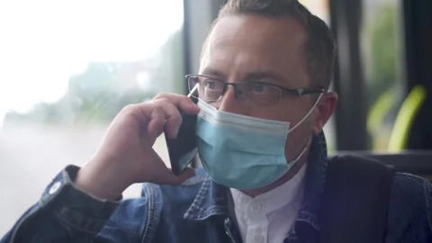 Man with phone inside of bus. Young man speaking by phone riding in bus. Stock Footage 156190536