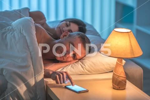 The man with a phone lay near sleeping woman Stock Photos