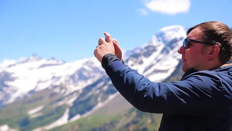 Man with a phone in the mountains Stock Footage 79260576