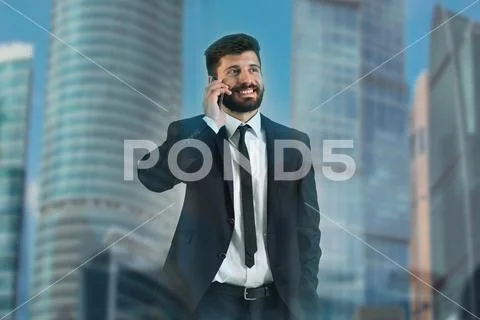 The man phone near the window on the background of a skyscraper Stock Photos