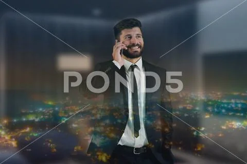 The man phone near the window with city lights Stock Photos