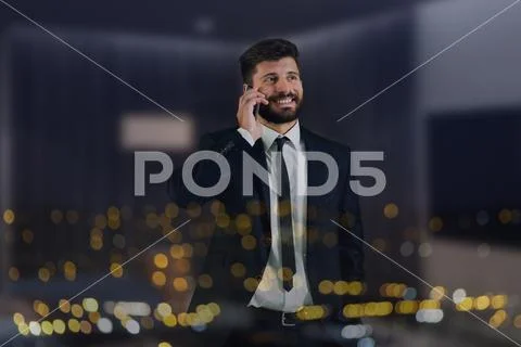 The man phone near the window with city lights Stock Photos