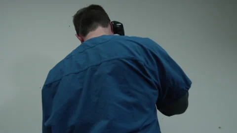 Man is on phone in prison when another inmate joins him and takes phone Stock Footage 202917719