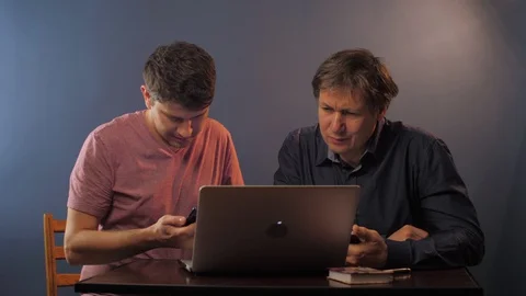 Man with phone shows how to input data to senior father Stock Footage 128486588