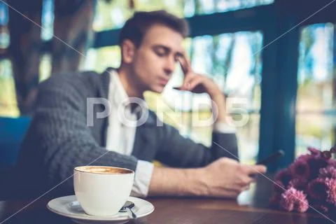 The man with a phone sit in the restaurant Stock Photos