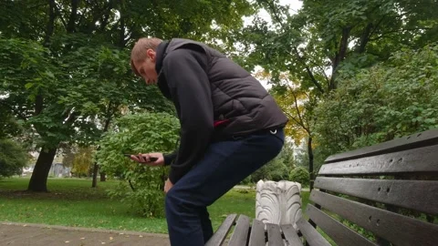 A Man With A Phone Sits On A Bench Stock Footage 162197929