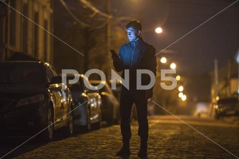 The man phone on the street. Evening night time. Telephoto lens shot Stock Photos