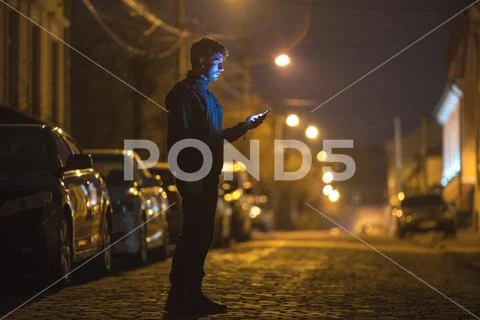 The man phone on the street. Evening night time. Telephoto lens shot Stock Photos