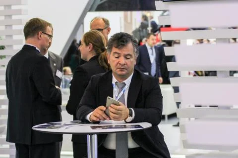 A man with a phone at the table. Stock Photos
