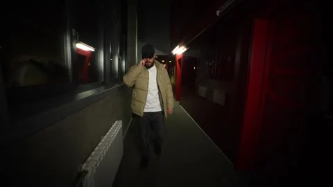 Man with phone walking down corridor and presses elevator call button 動画素材 253012252