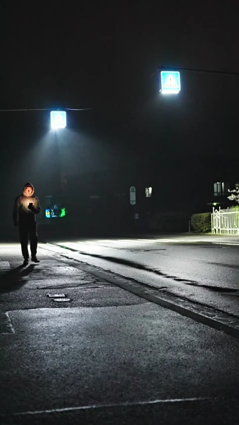 A man with a phone walks alone through the city, deep in thought on a dark night Stock Footage 307126939
