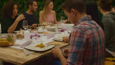 Man is on phone while dinner party outside Video stock 95316862