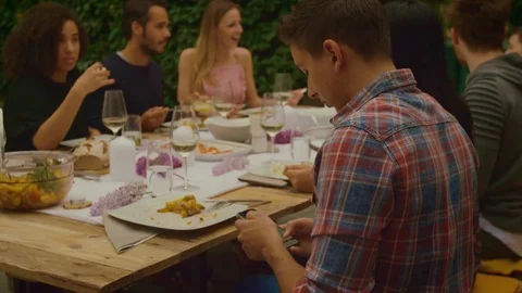 Man is on phone while dinner party outside Stock Footage 102827239