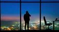 The man phones near the panoramic window on a night city background Photo