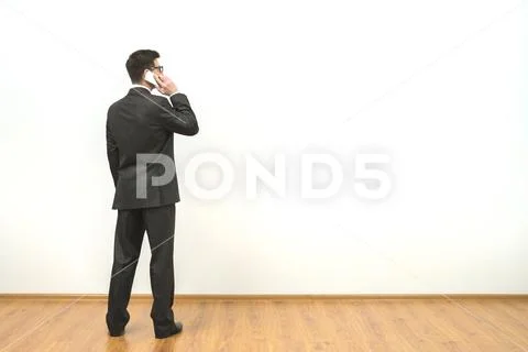 The man phones on the white wall background Stock Photos