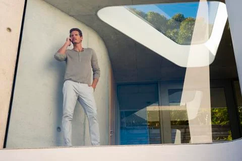 Man phoning behind window Stock Photos