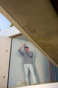 Man phoning behind window Foto stock