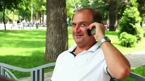 Man phoning on the bench on beautiful grass background Stock Footage 21317832