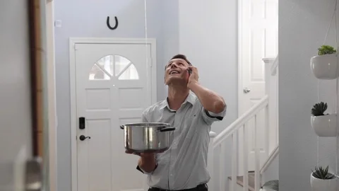 Man Phoning Emergency Plumber After Water Leak At Home Stock Footage 120893451