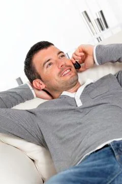 Man phoning on sofa Stock Photos