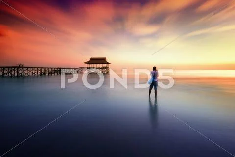 Man photographed sunset near the pier Stock Photos