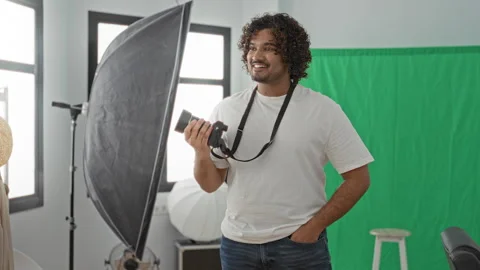 Man photographer holding camera with hand on hip in a studio with green scr.. Stock Footage 337402910