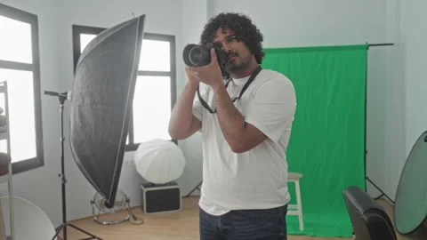 Man photographer holding camera with strap around neck, adjusting lens and .. Stock Footage 337396021