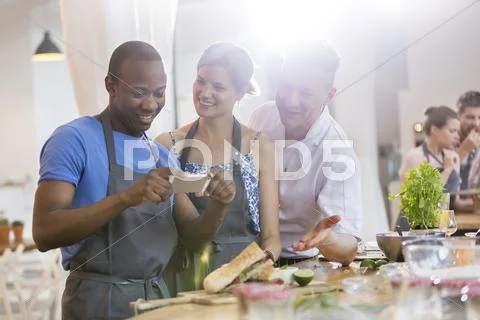 Man photographing food in cooking class kitchen Stock Photos