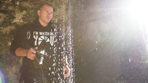 Man photographing under waterfall in slow motion Stock Footage 71567227
