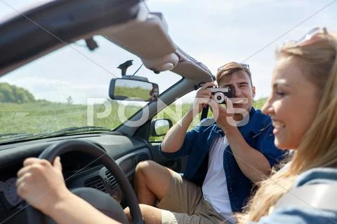 Man photographing woman driving car by film camera Stock Photos
