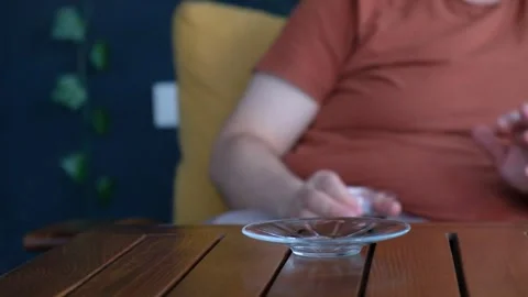 Man Picking Up and Drinking Tea from Glass Cup on Wooden Table Stock Footage 302687074