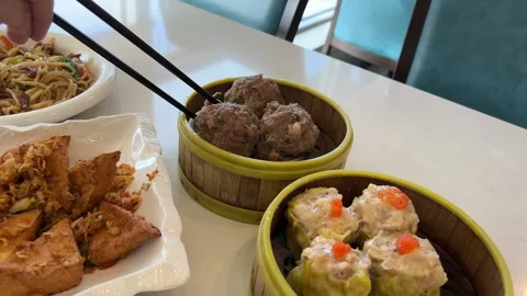 Man Picking Up Beef Meatball with Chopsticks at Restaurant Table Video stock 295783832