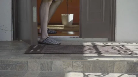 Man picking up a cardboard delivery box from the doorstep Stock Footage 343739391
