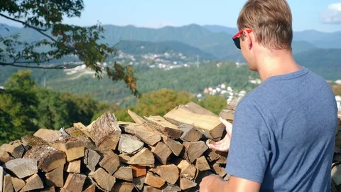 The man is picking up firewood. Stack of Wood for a Frosty Winter, for lighting Stock Footage 80491980