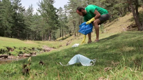 Man picking up garbage in the forest Stock Footage 137162970