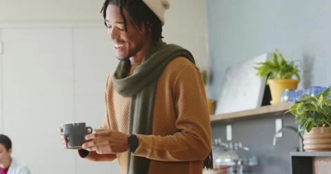 Man is picking mug at counter after tapping reader, then woman is stirring drink Stock Footage 339272058