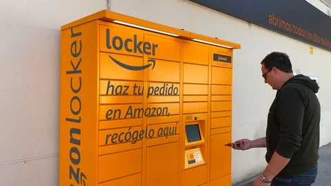 A man picking up a package at the Amazon hub Locker pick up point in Spain Stock Footage 122948301