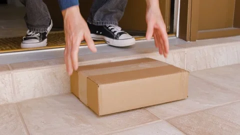 Man picking up a package delivery delivered to the doorstep. Stock Footage 150967754