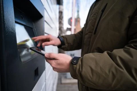 Man Picking Up A Parcel From Parcel Automated Locker 写真素材
