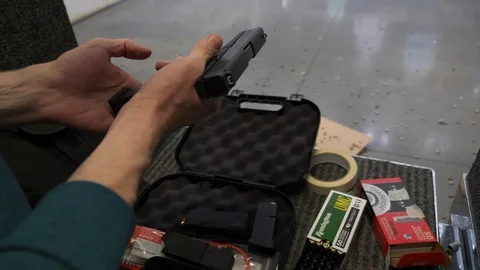 Man Picking Up Pistol, Loading and Aiming Down Range At Shooting Range Video stock 106124060
