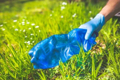 Man picking up plastic bottle, garbage collecting in forest cleaning planet Stock Photos