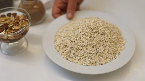 Man picking up a plate of oat flakes. Stock Footage 89532570