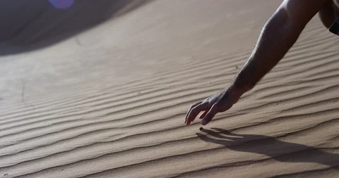 Man picking up sand on an untouched dune in a desert Stock Footage 107618600