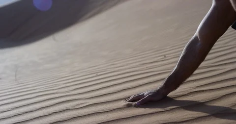 Man picking up sand on an untouched dune in a desert Stock Footage 107618708