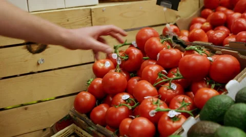 A man picking tomatoes at a local grocery store Stock Footage 57399952